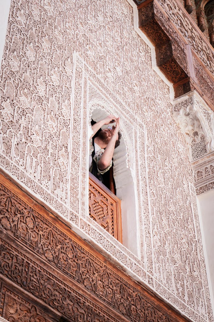 Explore the detailed Islamic architecture of Ben Youssef Madrasa in Marrakesh, featuring ornate carvings and traditional motifs.